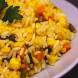 Plato de arroz amarillo con vegetales coloridos, una deliciosa receta llena de sabores y nutrientes.