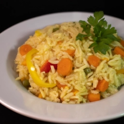 Plato de arroz amarillo con coloridas verduras, una deliciosa receta llena de sabor casero.