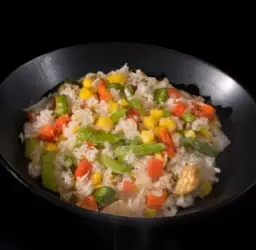 Plato de arroz salteado con coloridas verduras cocinadas al wok